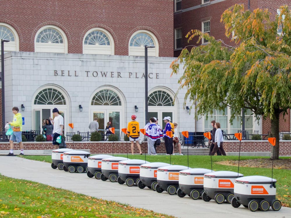 Grubhub robots sit lined up outside Bell Tower Commons.