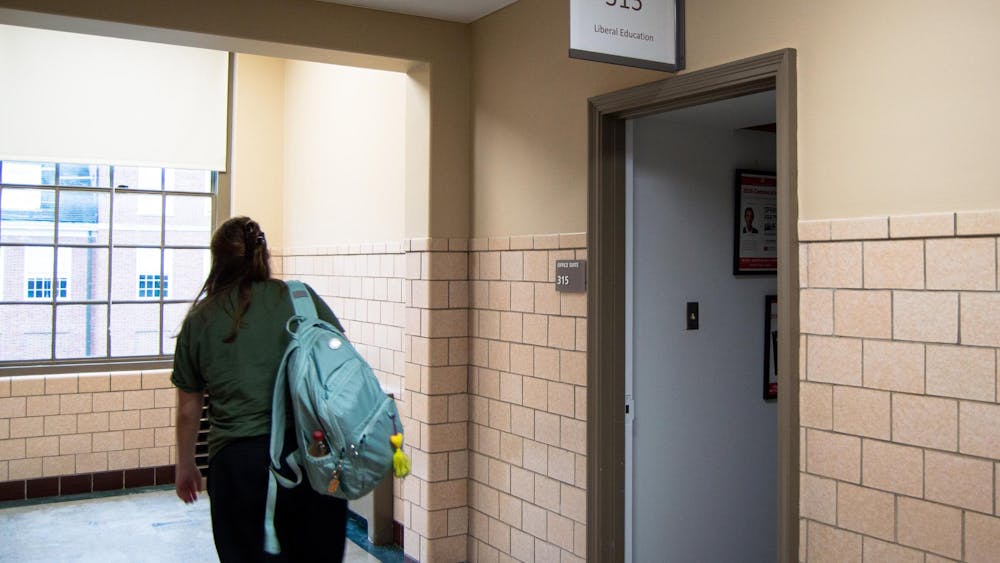 A student walks past the Office of Liberal Education in Laws Hall.
