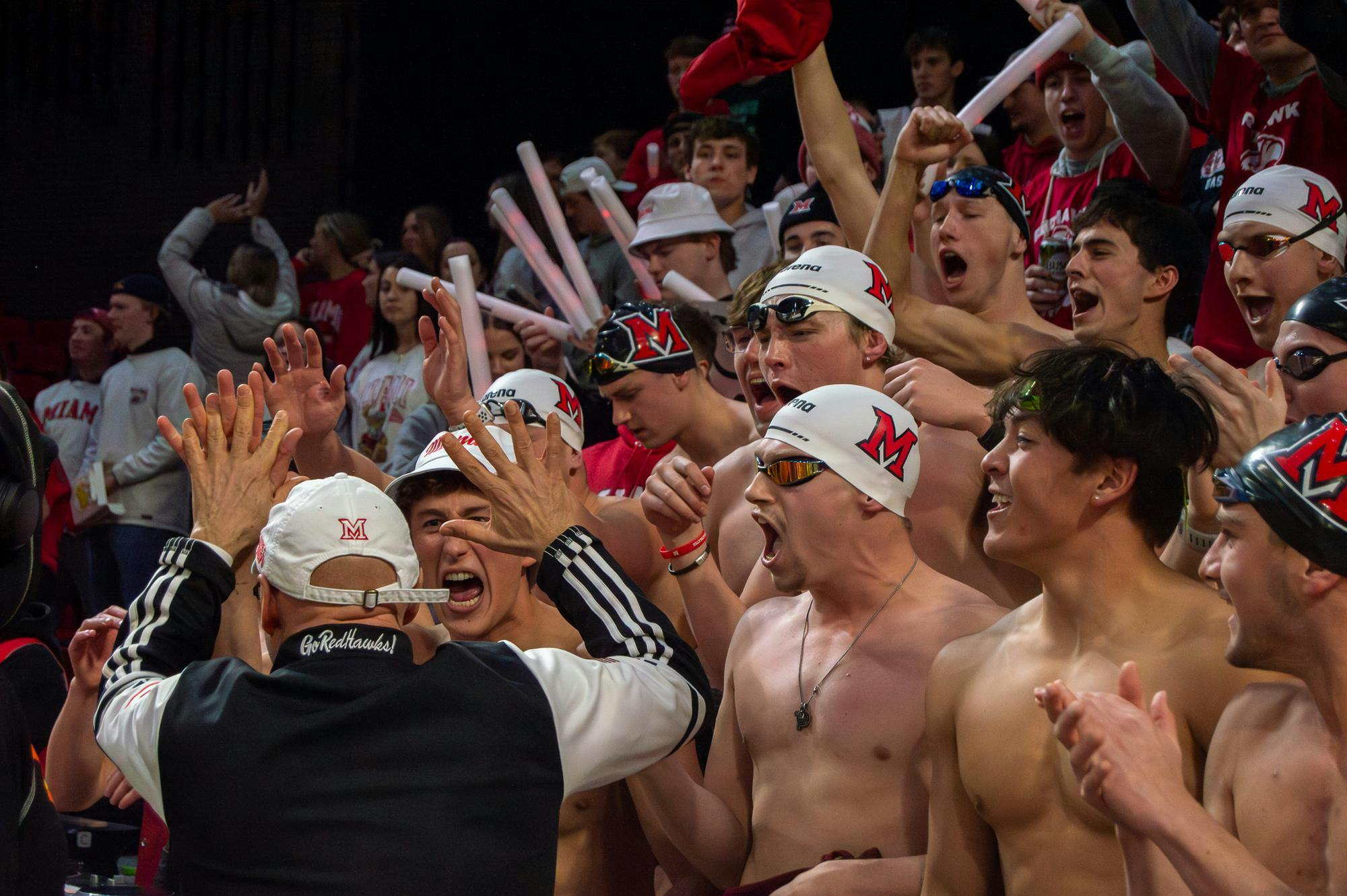 President Crawford high-fives members of the men’s swim and dive team as they cheer at the men’s basketball game on Jan. 31