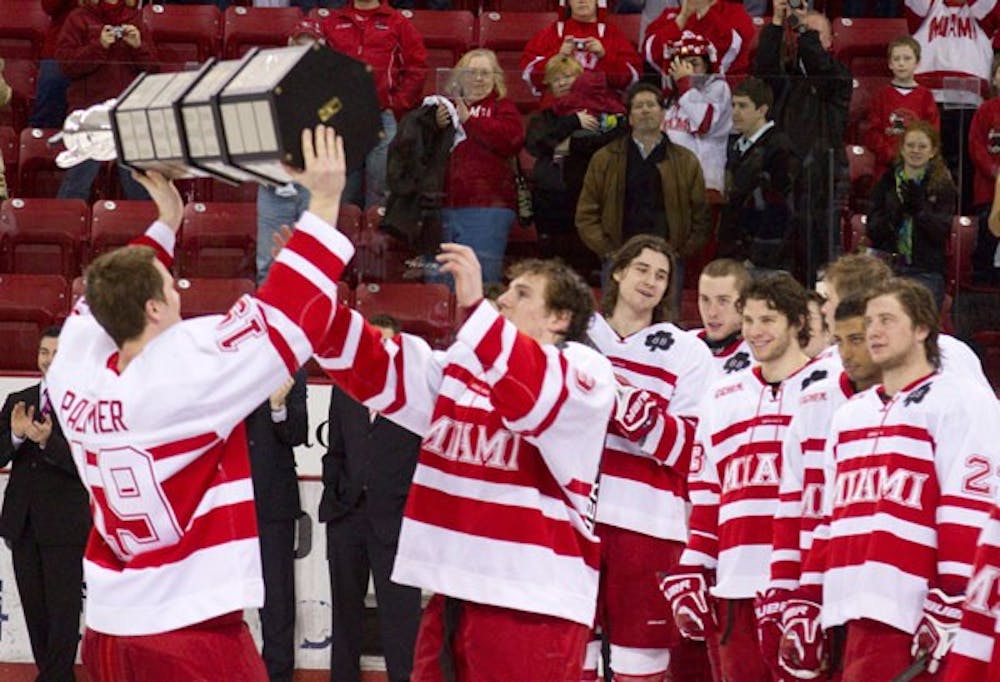 Senior Jarod Palmer shares the CCHA Regular Season Trophy with teammates during a ceremony after the game