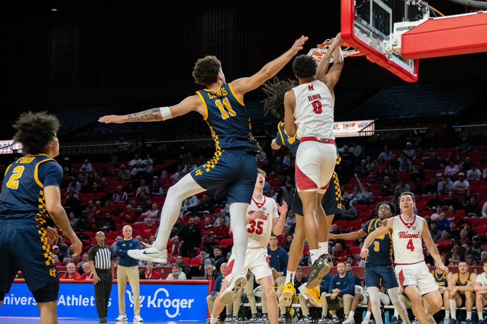 Sophomore wing Eian Elmer going for a dunk against two Toledo players at Millett Hall on Feb. 11