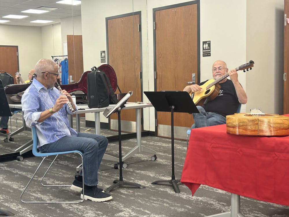 Latin jazz artist Nestor Torres and Miami professor Thomas Garcia rehearse for a performance together in the Center for Performing Arts' green room.
