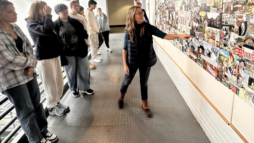 Liz Martin, the department chair of architecture and interior design, views the Architecture 113 class's collages.