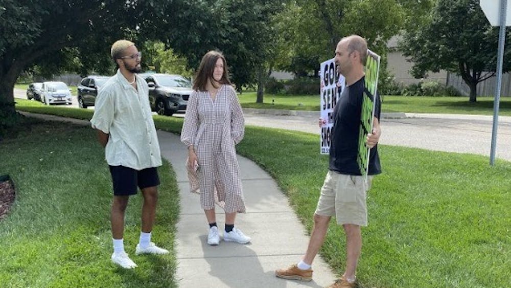 Researchers Jayson Meggysey (left) and Annalise Chapdelaine (center) speak with a member of the Westboro Baptist Church (right) at a picket.