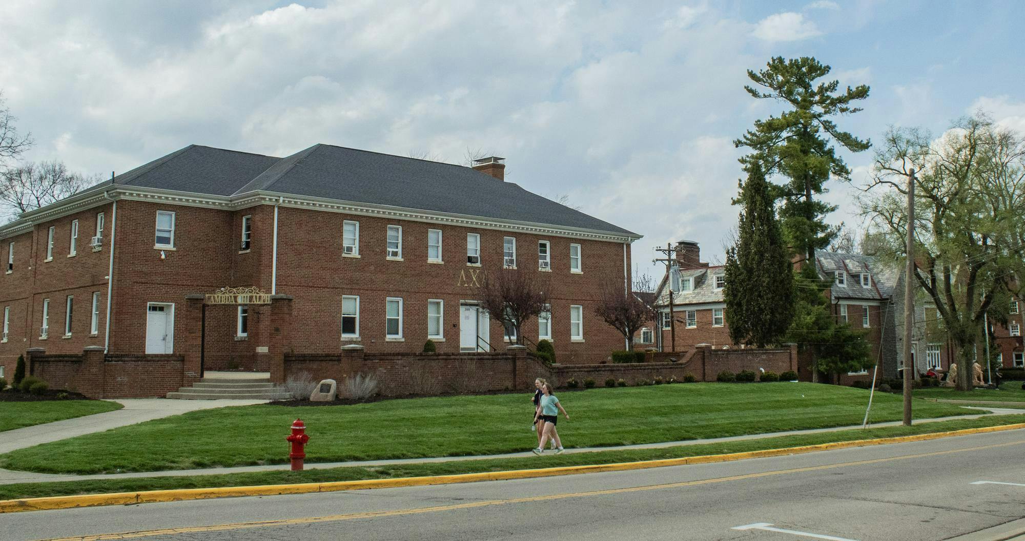 Students walking in front of Lamada Chi Alpha fraternity house on Tallawanda Road.