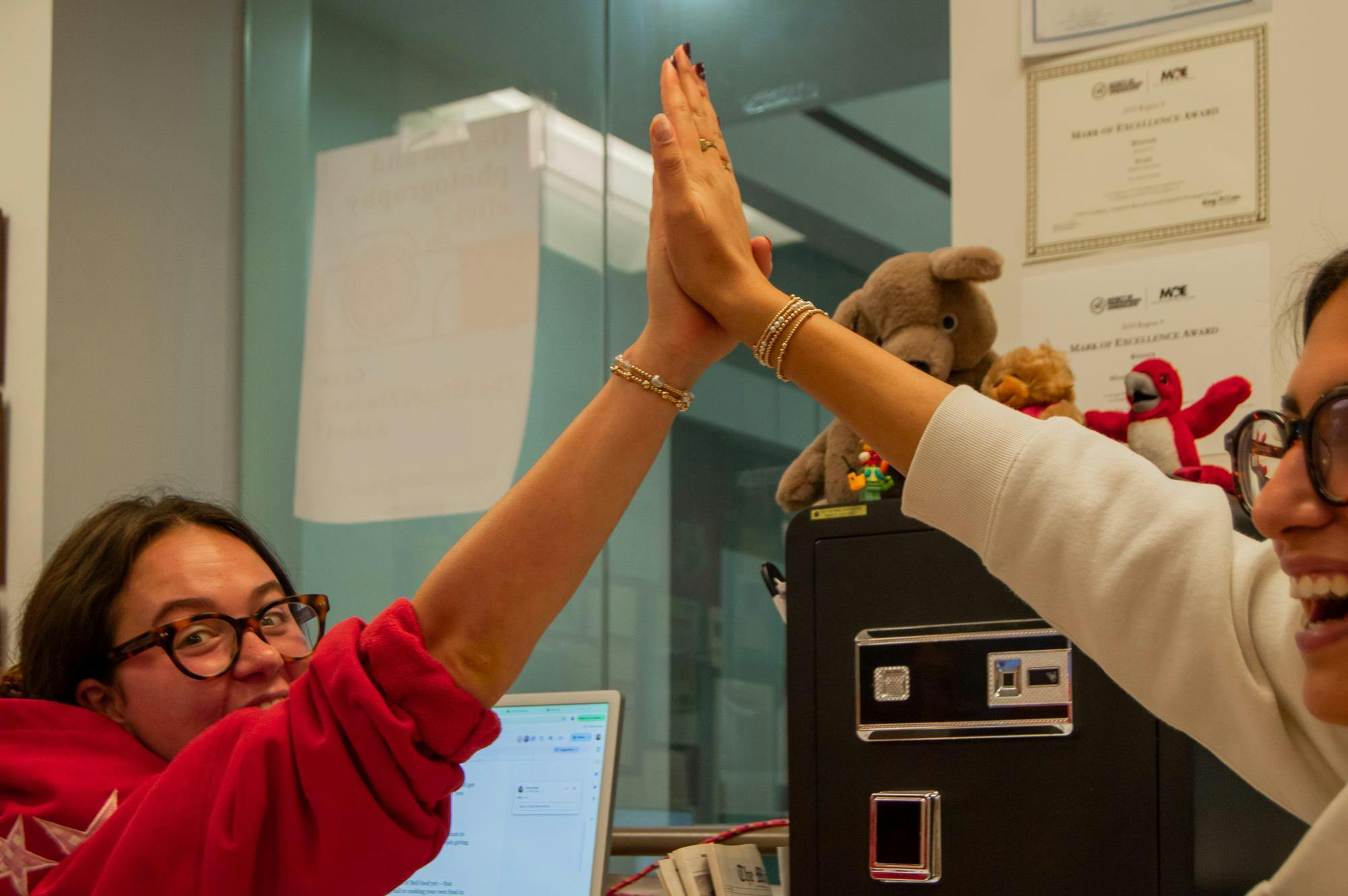 Anna Reier and Olivia Patel share a high-five during a production night in the TMS newsroom.