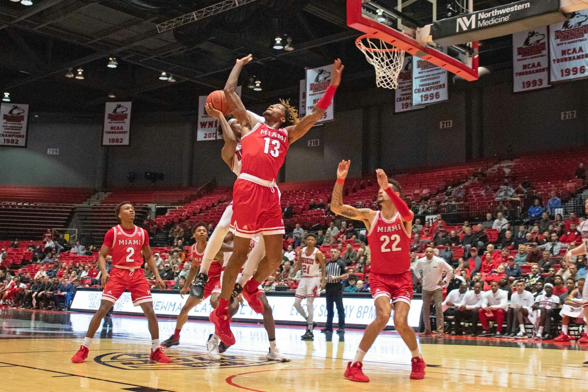 Junior forward Dalonte Brown (No. 13) and sophomore forward Eli McNamara attempt to block a Northern Illinois shot during a 70-55 Miami loss to the Huskies Feb. 1.