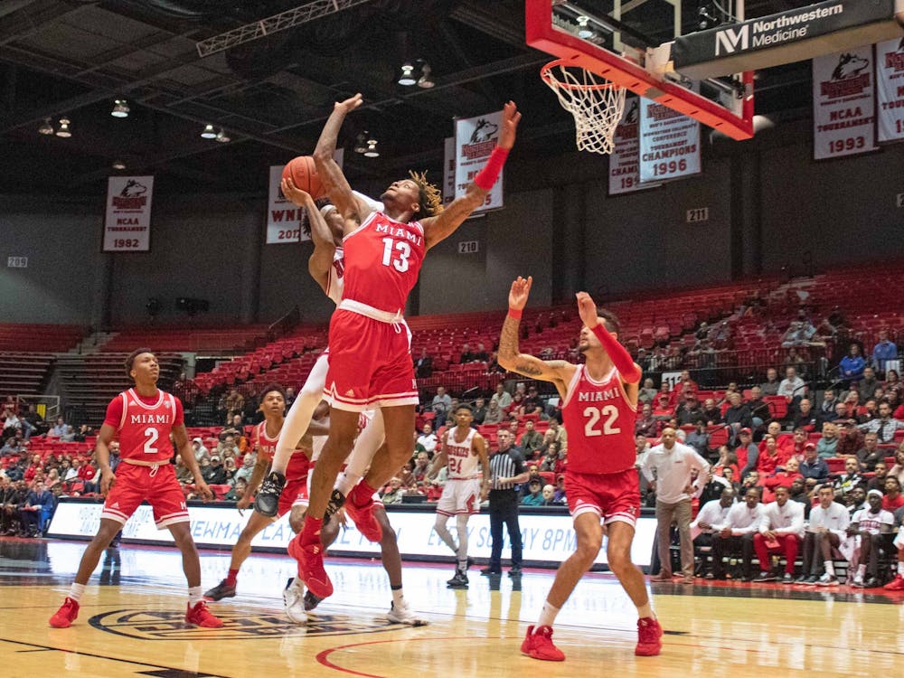 Junior forward Dalonte Brown (No. 13) and sophomore forward Eli McNamara attempt to block a Northern Illinois shot during a 70-55 Miami loss to the Huskies Feb. 1.