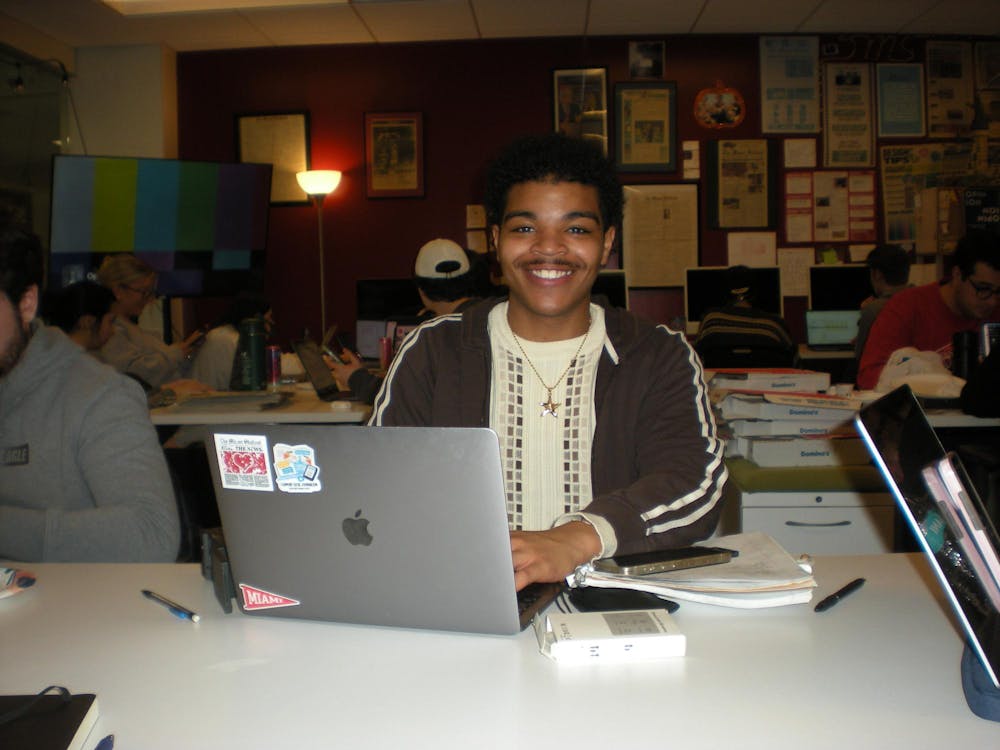 Kiser Young, Social Media Editor, works on his laptop at a production night.
