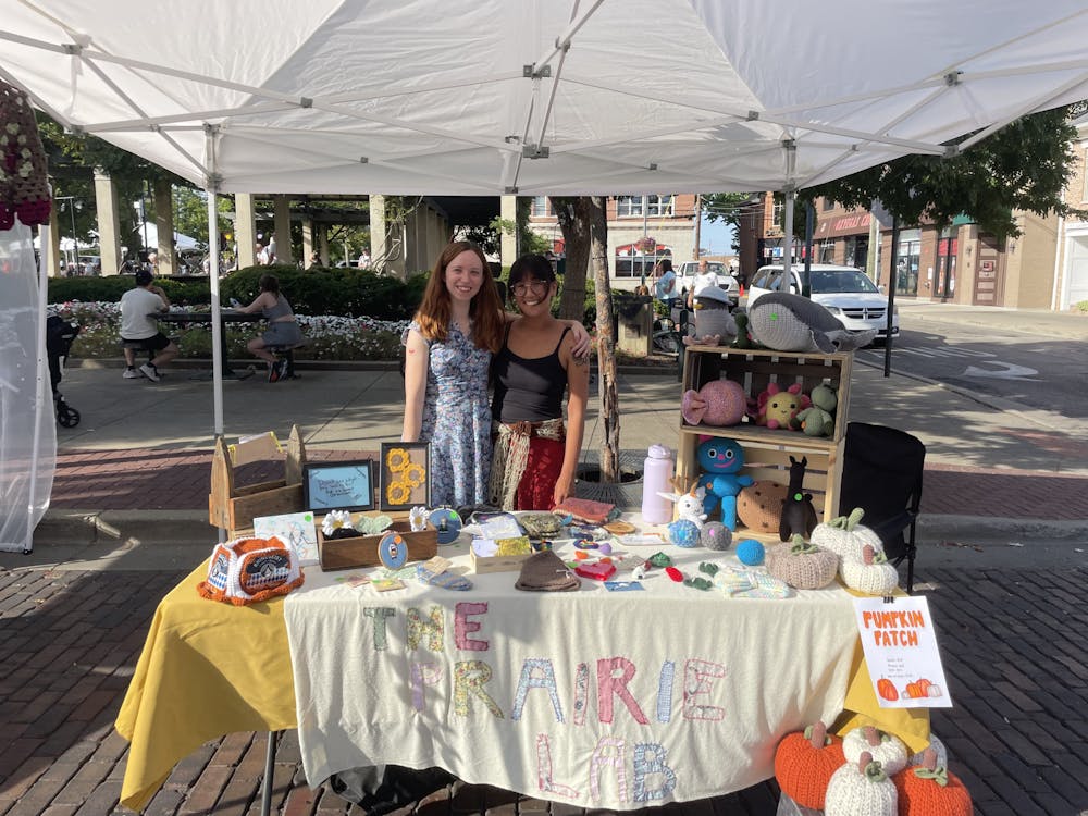 <p>Grace Brock (left) is part of the Prairie Lab, a local business in Oxford. The team sets up their booth at Oxtoberfest.</p>