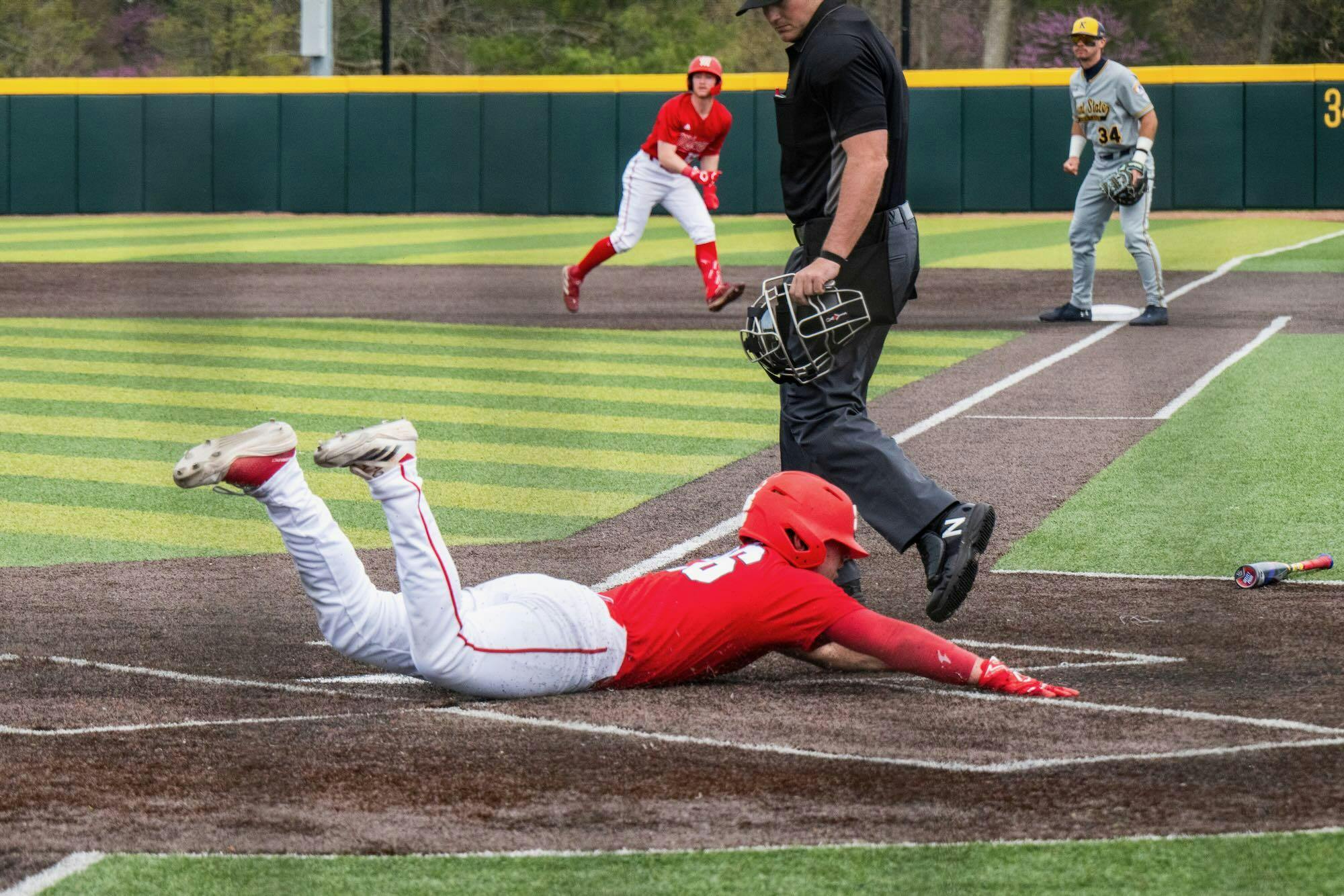 Evan Appelwick dives for home plate against Kent State at McKie Field on April 13