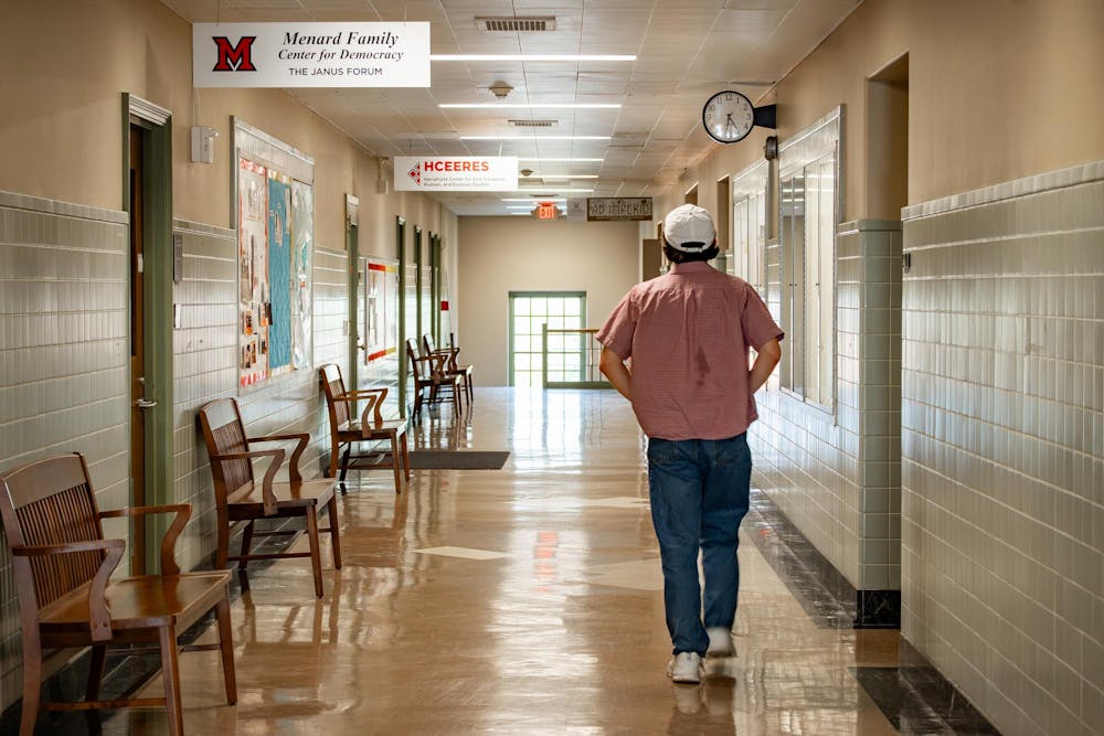 A student walks past the Menard Family Center for Democracy located in Harrison Hall.