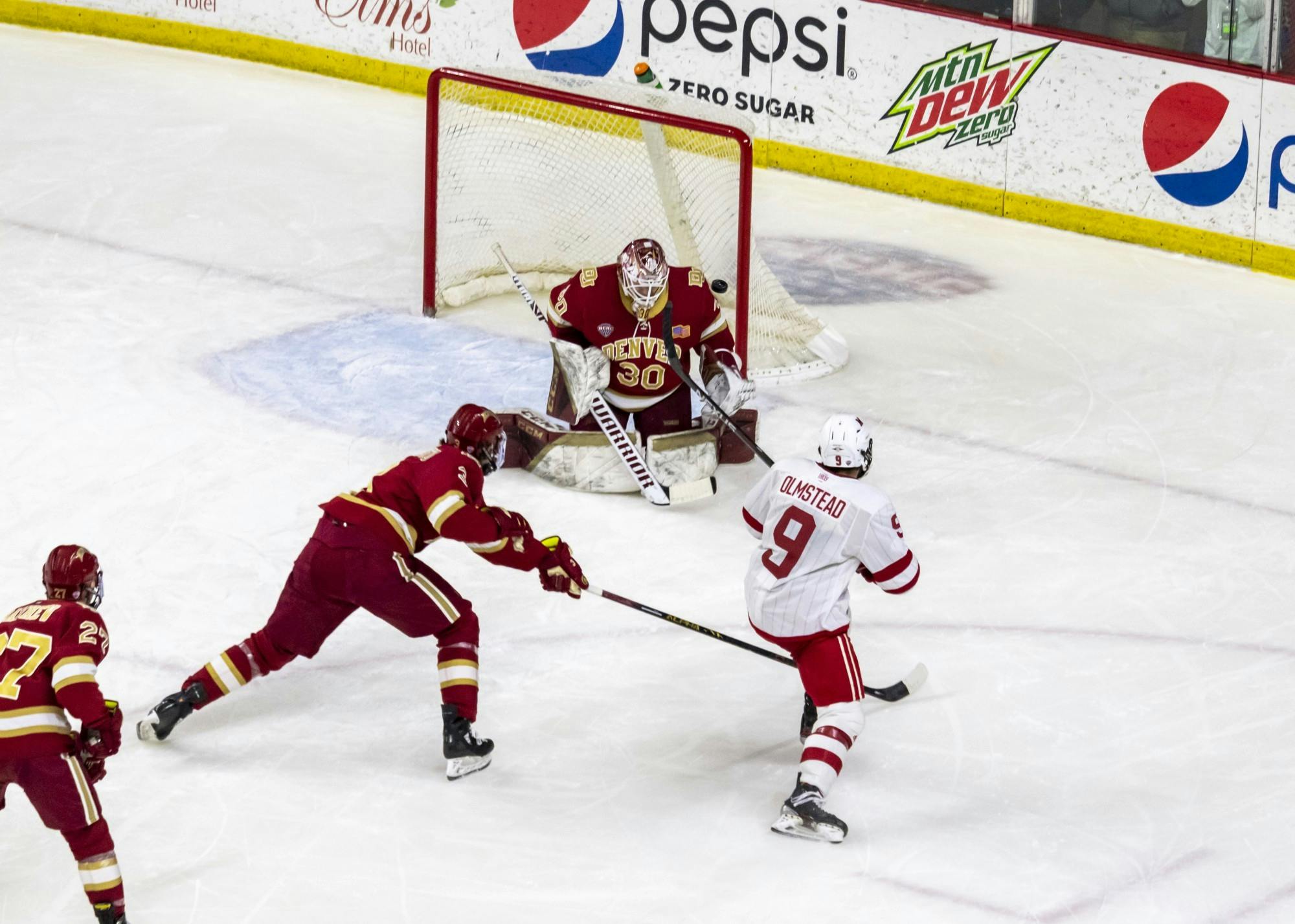 Senior forward Jack Olmstead sends a shot past Denver's goalie in a weekend series against the Pioneers.