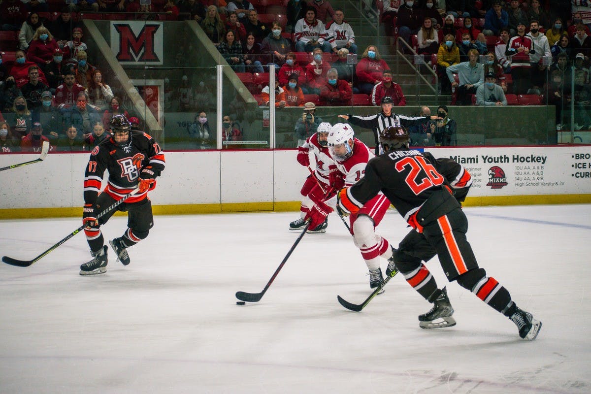 Senior defenseman Derek Daschke skates through a pair of Bowling Green defenders with the puck during Miami&#x27;s Oct. 22 tie vs. the Falcons.