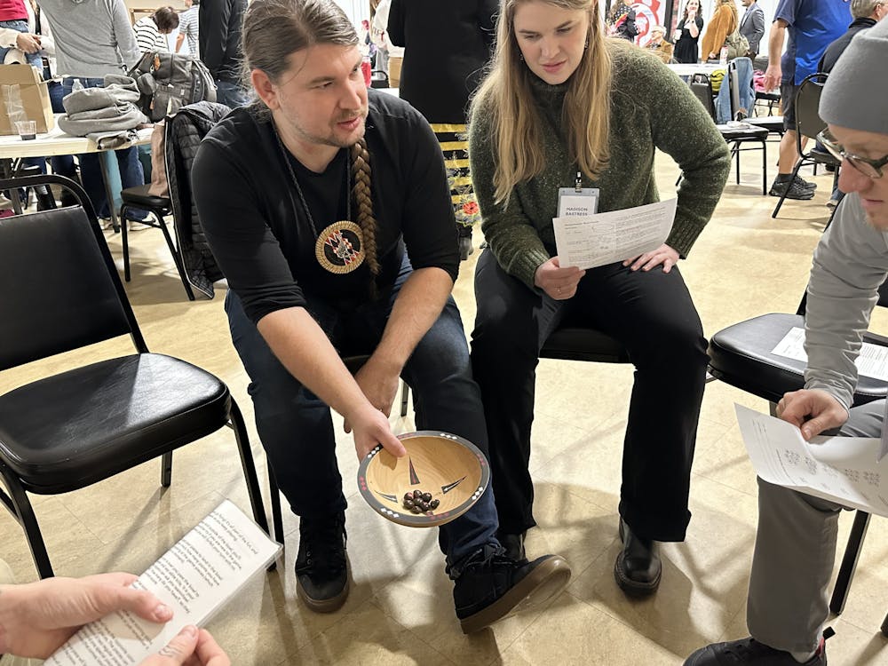 <p>Jared Nally shows guests how to play the plum stone game.﻿</p>