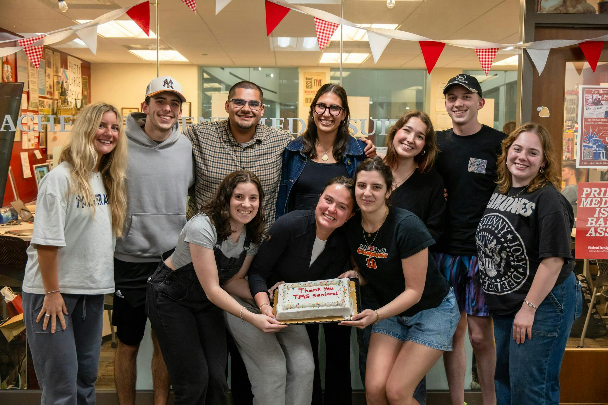 The class of 2026 staff poses with an end of year celebration cake. 