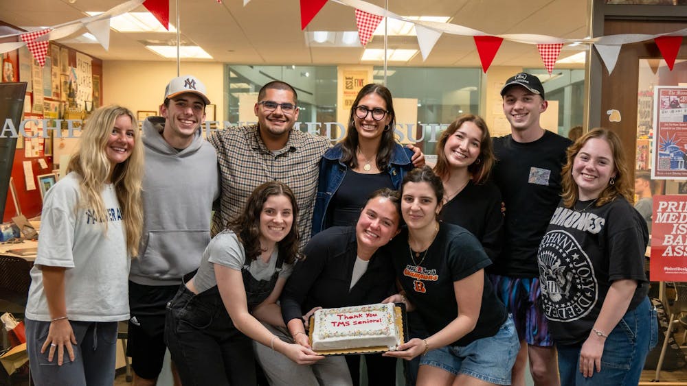 The class of 2026 staff poses with an end of year celebration cake.