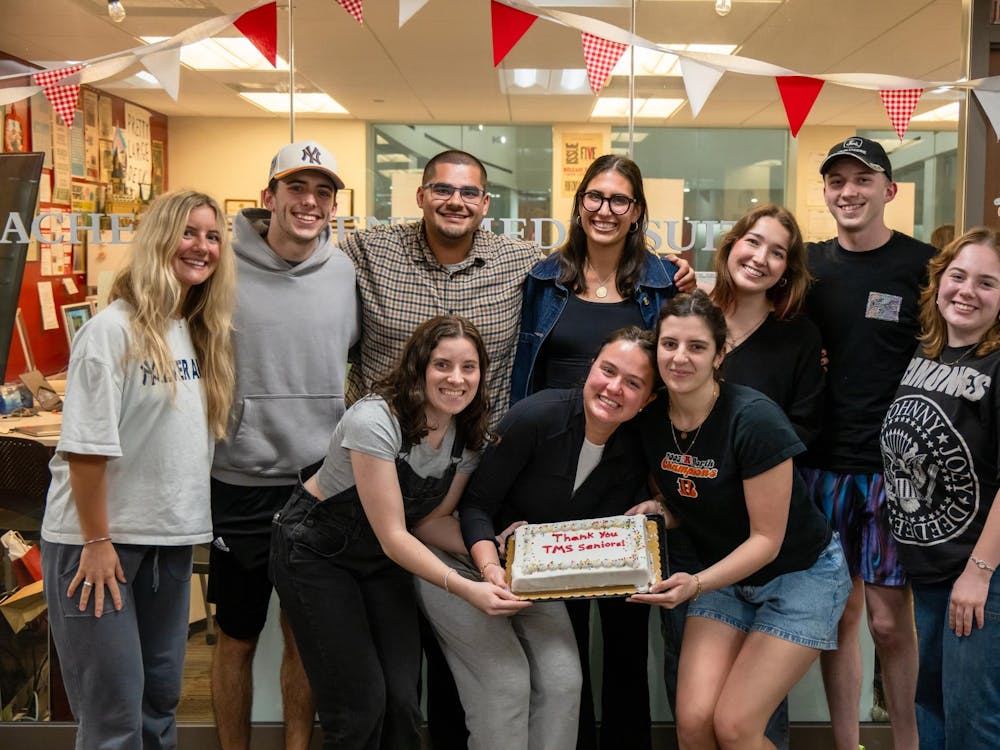 The class of 2026 staff poses with an end of year celebration cake.