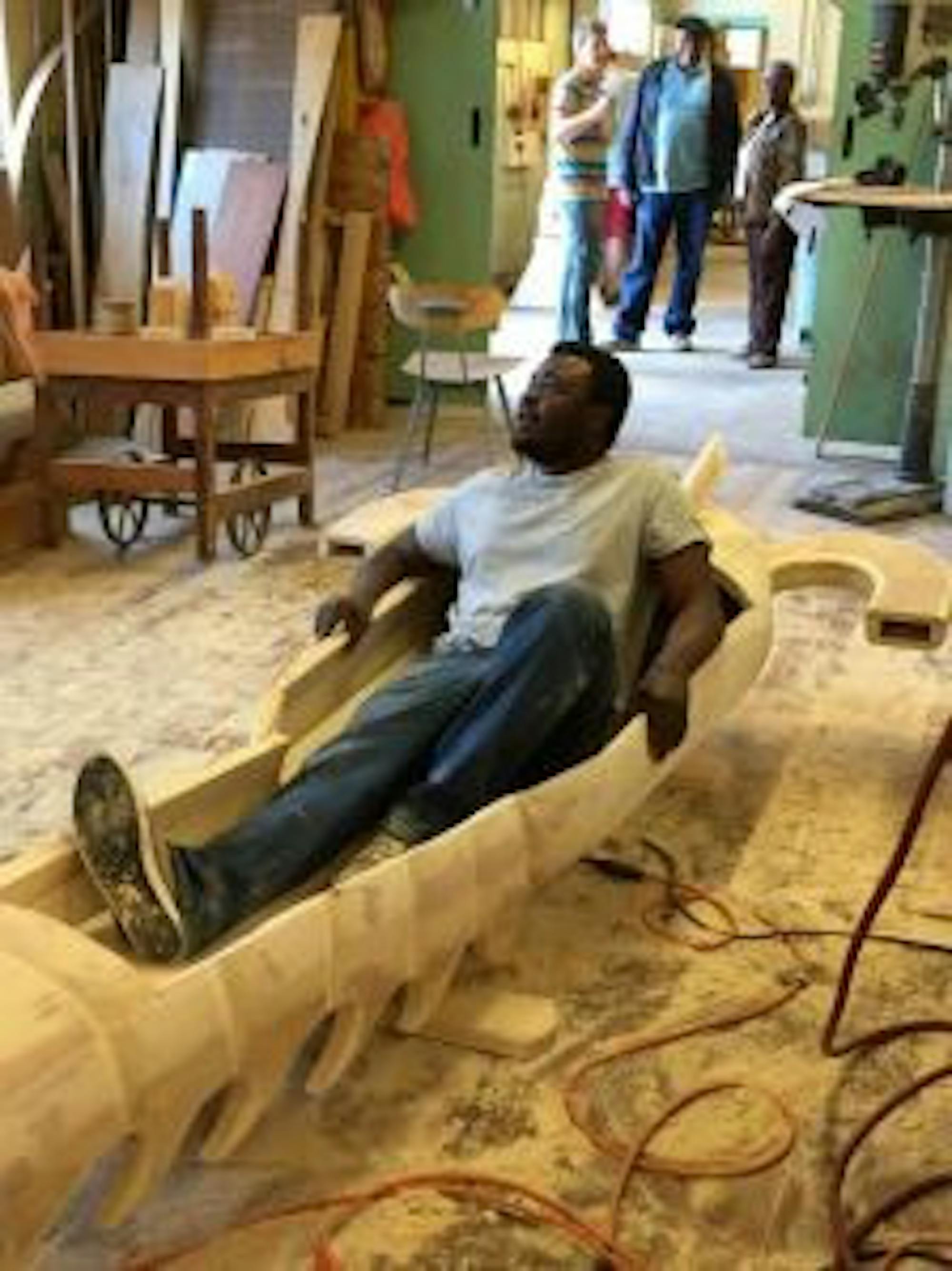 Olivia Marple/Contributing Eric Anang sits in the lobster coffin that he and his team made in New Hampshire. He has been working in the UNH Woodshop Service Building to present his work.