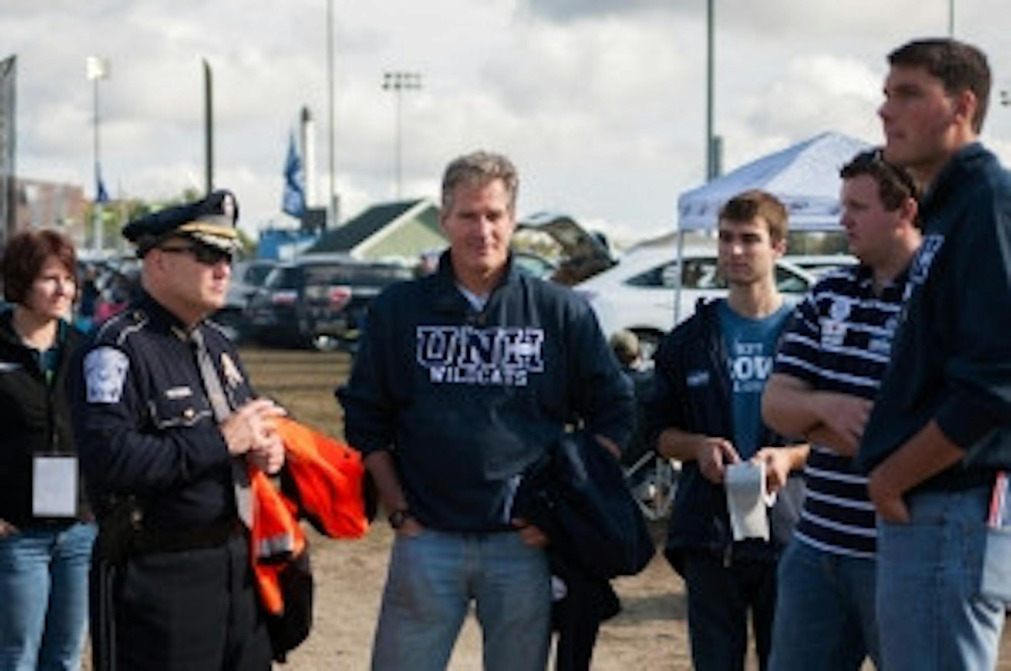 Cameron Johnson/staff Scott Brown, escorted by UNH Police Paul Dean, enters Homecoming. He spent his time talking to students, and catching up with an old basketball referee from Tufts.
