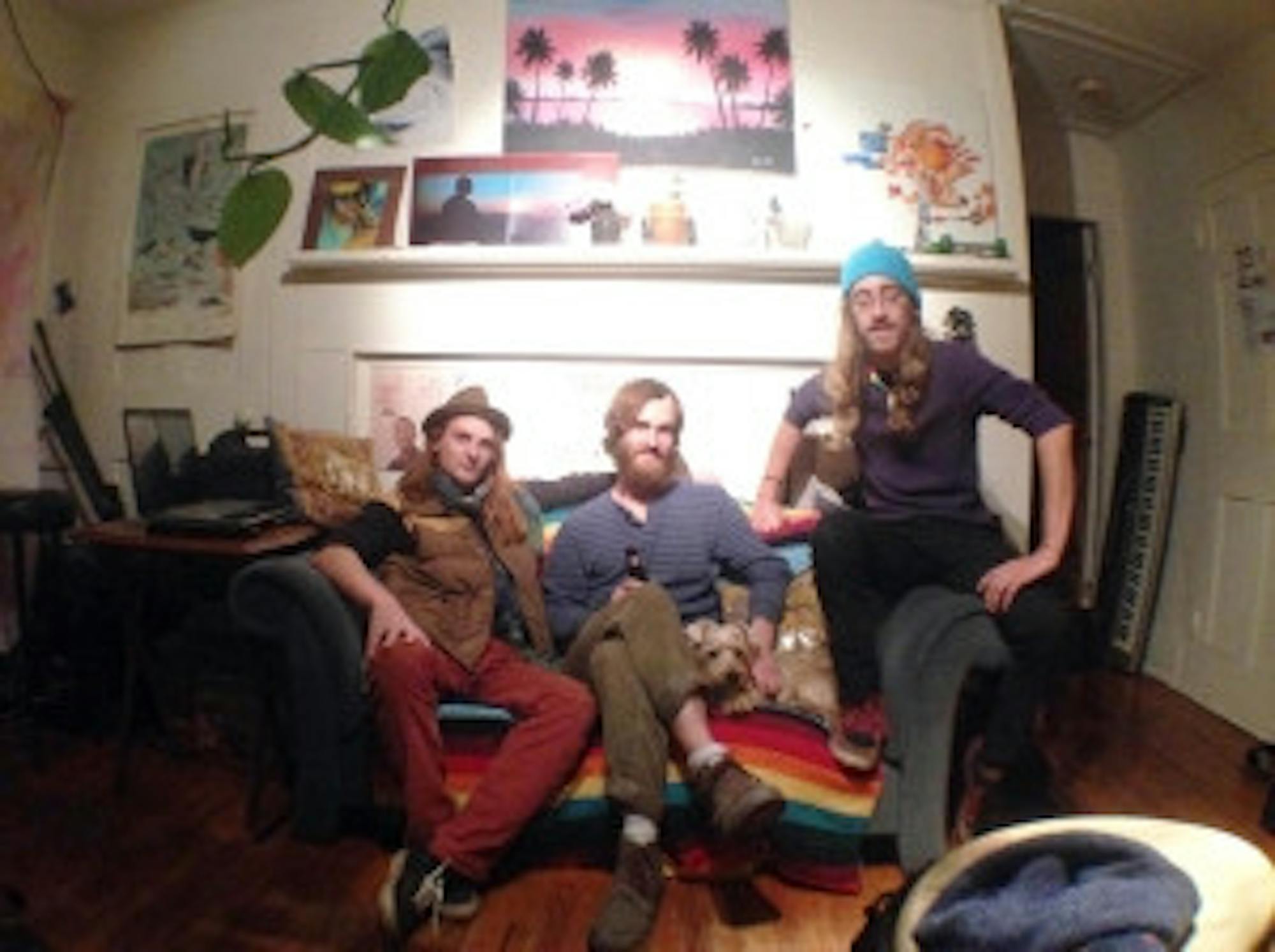 Charlie Weinmann/Staff The three members of The Raunchy Randos, Stefan Trogisch, Lucas Perry and Shane Devanney, and their dog Buddy pose in their living room-turned-recording studio on Church Street in Newmarket, New Hampshire. They have recorded each of their EPs in this room, independently producing and releasing their music to the public.