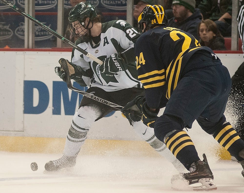 <p>Junior forward Joe Cox looks to control the puck against Michigan defenseman Kevin Lohan Jan. 30, 2015, during the game against Michigan at Joe Louis Arena in Detroit, Michigan. The Spartans beat the Wolverines, 2-1. Alice Kole/The State News</p>
