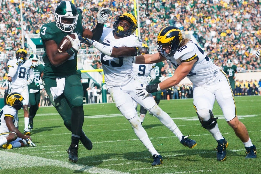 Sophomore running back L.J Scott (3) runs the ball up the field while being tackled by Michigan safety Nate Johnson (25) during the game against Michigan on Oct. 29, 2016 at Spartan Stadium. The Spartans were defeated by the Wolverines, 32-23.