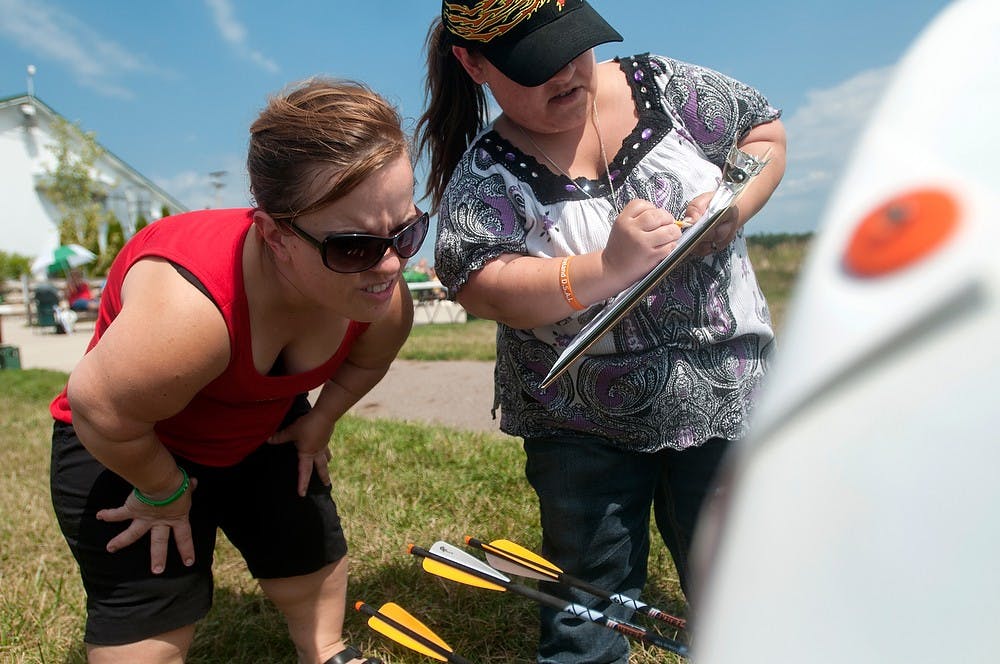 	<p>Tuscon, Ariz., resident Amy Morris, left, and Holt, Mich., resident Joelle Humes score their arrows Aug. 7, 2013, during the World Dwarf Games at Demmer Shooting Sports, Education and Training Center.  Morris shot a 29 for the round. Weston Brooks/The State News  </p>