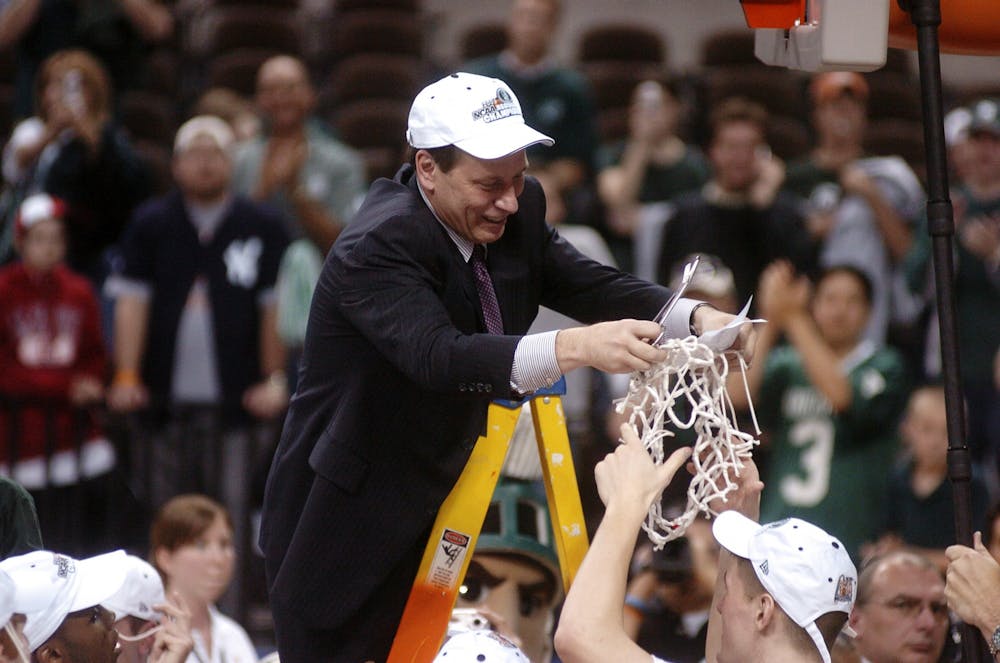 Michigan State head coach Tom Izzo hands the net to junior center Paul Davis after defeating Kentucky and winning a trip to the Final Four. Clint Spaulding/The State News