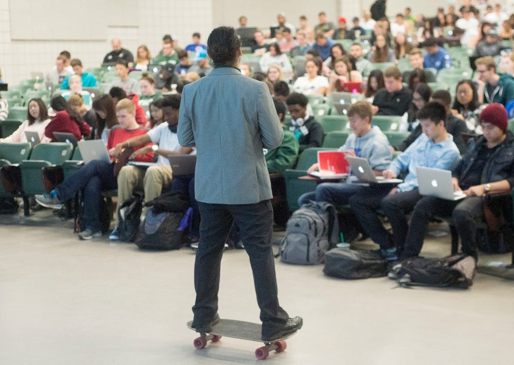 <p>Media and information assistant professor Rabindra Ratan skateboards around his classroom on Sept. 22, 2015 in Wells Hall. Ratan's class starts at 8:30 in the morning and he believes skateboarding while he teaches helps his students to stay awake and focused on the lecture.</p>