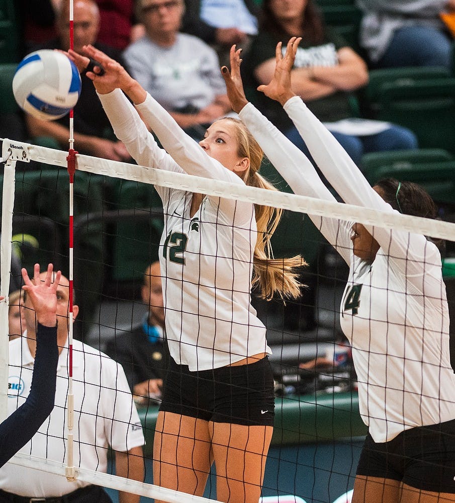 <p>Freshman setter Rachel Minarick and senior middle blocker block the ball Oct. 3, 2014, during a game against the University of Michigan at Jenison Fieldhouse. The Spartans defeated the Wolverines, 3-1. Erin Hampton/The State News</p>