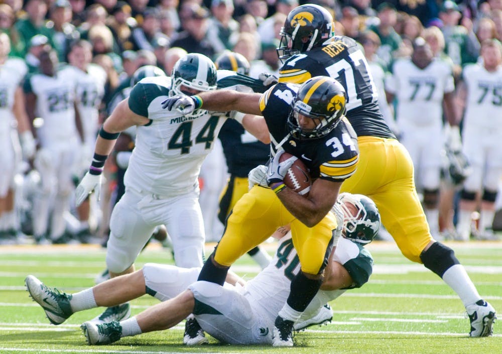 Sophomore linebacker Max Bullough drags down Iowa running back Marcus Coker Saturday at Kinnick Stadium in Iowa City, Iowa. The Spartans defeated the Hawkeyes 37-21. Matt Radick/The State News