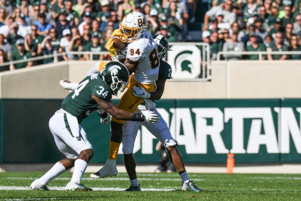 <p>Then-junior cornerback Josiah Scott (22) and then-junior linebacker Antjuan Simmons (34) tackle a Sun Devils receiver during the game against Arizona State on Sept. 14, 2019, at Spartan Stadium. The Spartans fell to the Sun Devils, 10-7.</p>