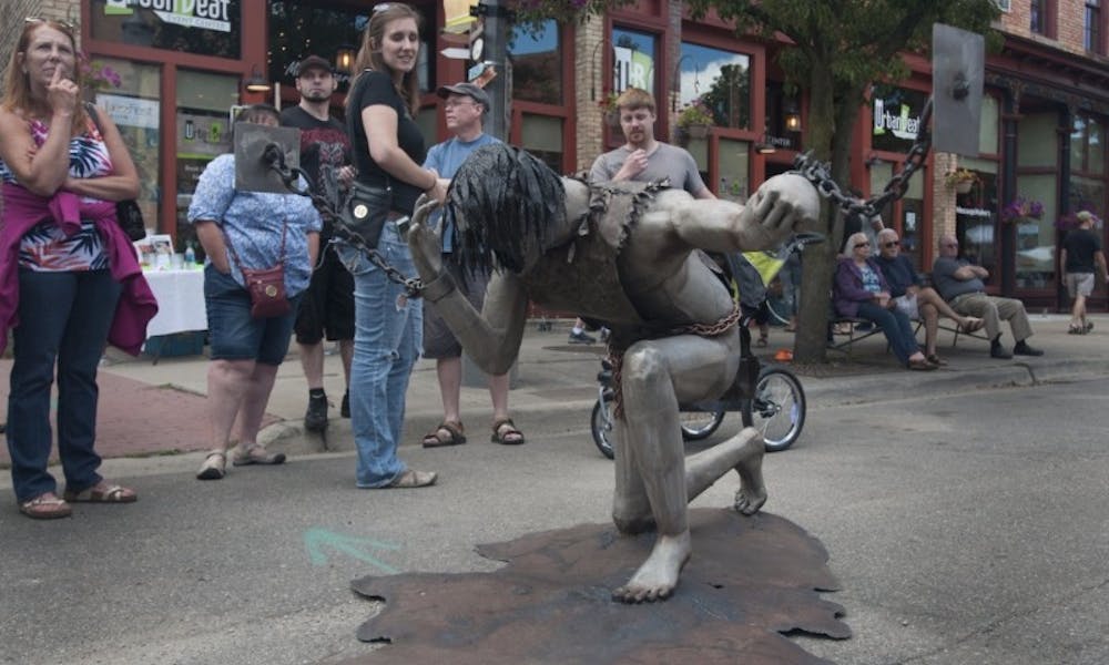 Festival attendees contemplate Jackson resident Kyle Orr's sculpture "Bezalels Art" at Scrapfest on July 16, 2016 in Lansing's Old Town.
Emilia McConnell | The State News