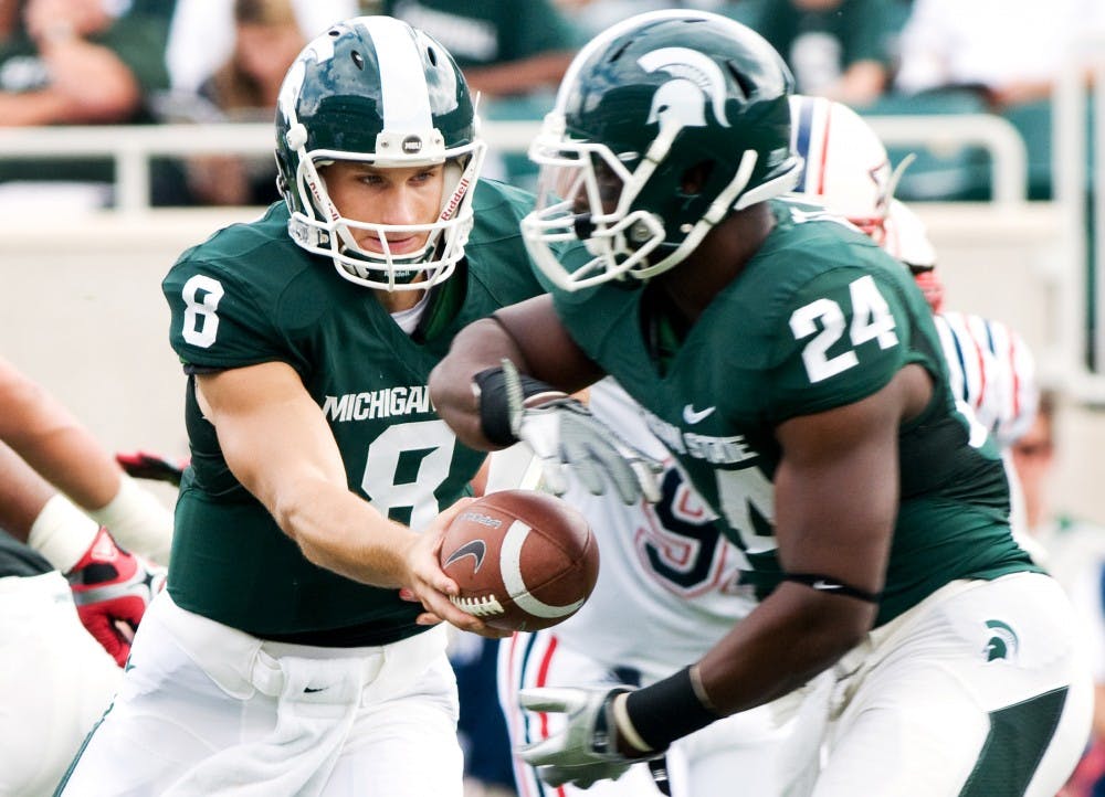 Senior cornerback Kirk Cousins hands off to sophomore running back Le'Veon Bell Saturday at Spartan Stadium. The Spartans defeated the Florida Atlantic Owls 44-0. Matt Radick/The State News