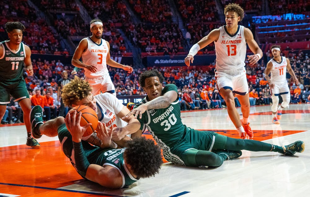 <p>Junior forward Malik Hall (25) and senior center Marcus Bingham Jr. (30) fight for possession of the ball from an Illinois player during the first half. The Spartans lost to the Fighting Illini in the final seconds, 56-55, at State Farm Center on Jan. 25, 2022. </p>