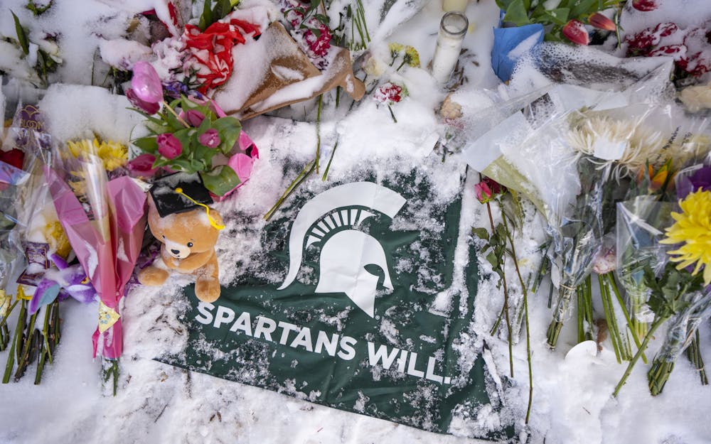 The memorial for Brian Fraser, Arielle Anderson and Alexandria Verner on Friday, Feb. 17, 2023, at the Rock on Farm Lane. Memorials started across campus after the three were killed and five more were critically injured by a mass shooting in MSU’s north campus on Feb. 13. 