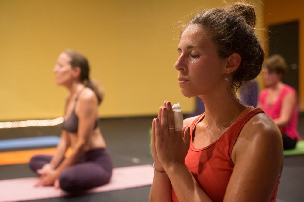 <p>Sustainable agriculture senior Hannah Flood mediates after her yoga practice on Sept. 1, 2015, at East Lansing Hot Yoga, 924 Trowbridge Road, in East Lansing.</p>
