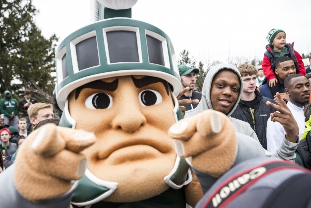 <p>Freshman guard Cassius Winston (5) and Sparty pose during Miles Bridges's announcement that he will be continuing his MSU basketball career in the 2017-2018 season on April 13, 2017 at The Spartan statue. Hundreds of students gathered around the statue in support of Miles Bridges's return to MSU.&nbsp;</p>