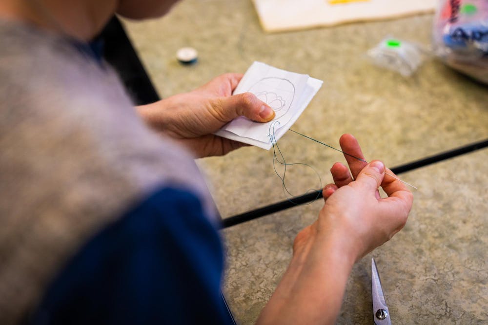 An MSU student runs a needle and yarn through an original design during a beading workshop held at the Urban Planning and Landscape Architecture building on Nov. 19, 2024.