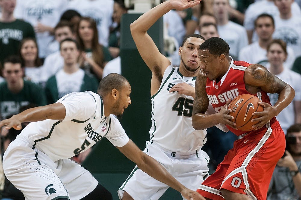 	<p>Senior center Adreian Payne, 5, and sophomore guard Denzel Valentine, 45, defend Ohio state guard Lenzelle Smith Jr. on Jan. 7, 2014, at Breslin Center. The Spartans are leading at the half, 28-21. Danyelle Morrow/The State News</p>