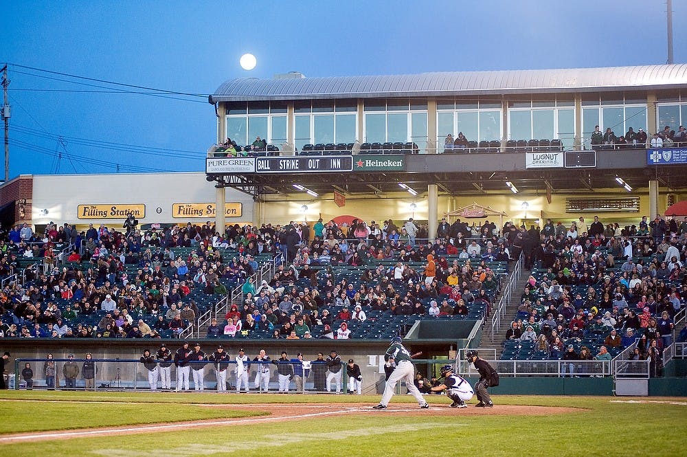 	<p>The moon shows up on the roof of Cooley Law School Stadium in Lansing April 5, 2012, as then sophomore catcher and infielder Joel Fisher is about to swing. The Spartans fell to the Lugnuts by a score of 7-0 at Cooley Law School Stadium during the Crosstown Showdown. State News File Photo</p>