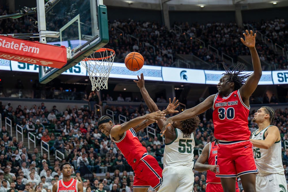 Michigan State forward Coen Carr (55) goes for a shot as Detroit Mercy guard Nate Johnson (10) and forward Ryan Kalambay (30) try to block it during Michigan State’s game against Detroit Mercy at Breslin Center in East Lansing, Mich., on Friday, Nov. 21, 2025.