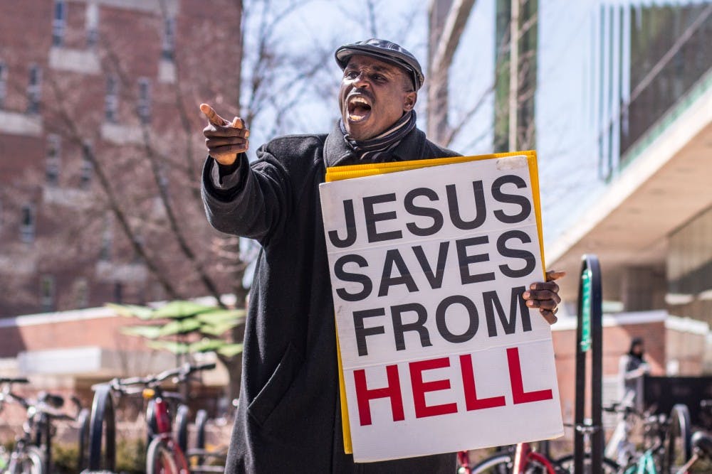 Pastor Michael Venyah of Soul Winners Fellowship Church preaches outside of Wells Hall on March 26, 2018. The church has a worship service every Sunday at 11 a.m. and Bible study on Wednesdays at 7 p.m.
