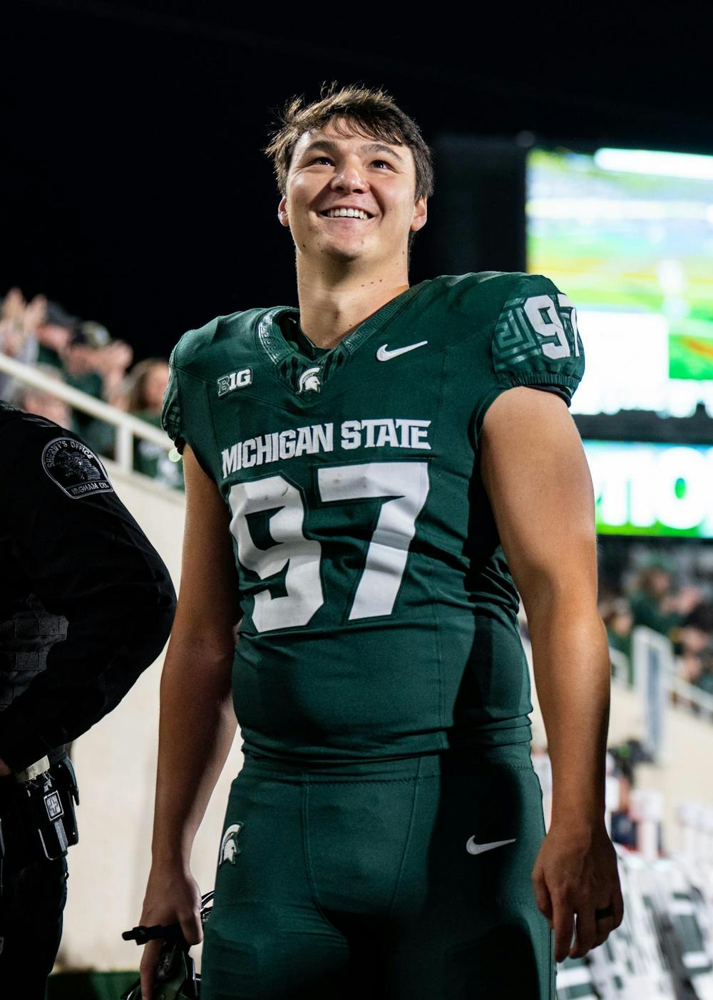 <p>Michigan State University sixth year kicker Jonathan Kim smiles while looking at the scoreboard during the game against the University of Iowa at Spartan Stadium on Oct. 19, 2024. Kim made six field goals during the game, setting a school record.</p>