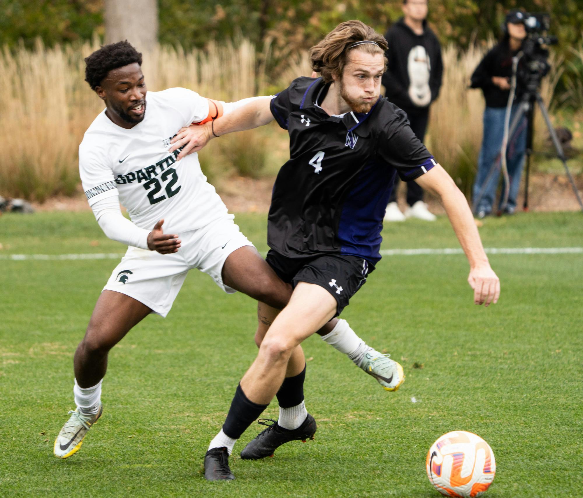 Redshirt senior defender Will Perkins (22) tries to get the ball off of Northwestern’s sophomore midfielder Collin McCamy (4) during a game at DeMartin Stadium on Oct. 30, 2022. The Spartans lost to the Wildcats with a score of 2-1. 