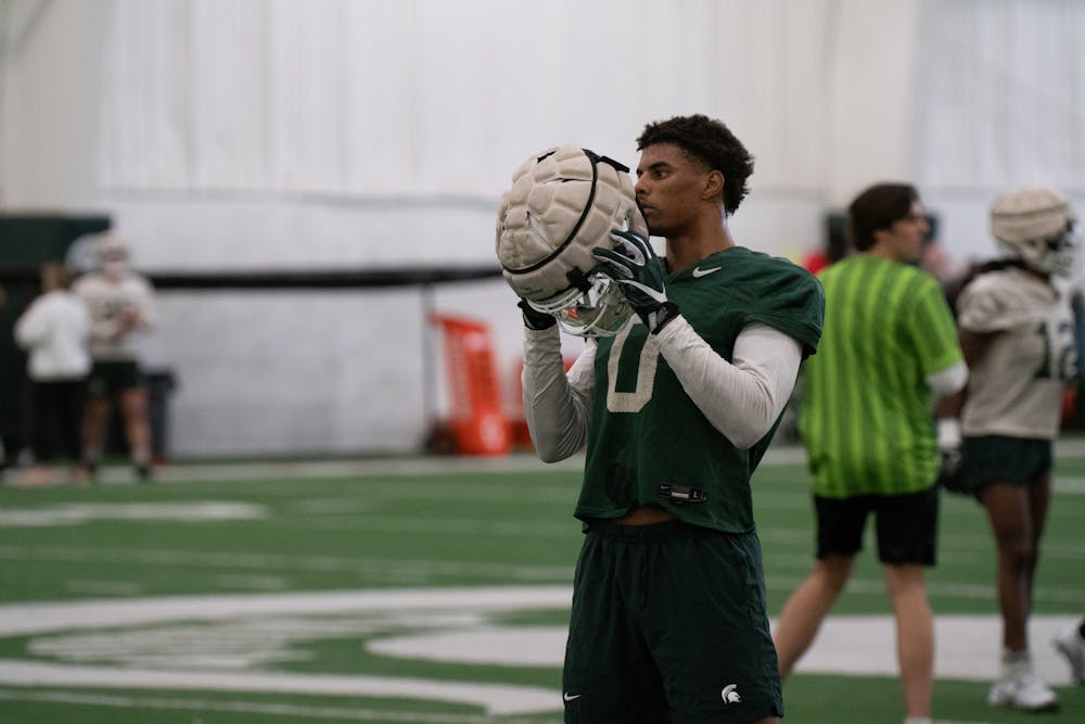 MSU junior wide receiver Keon Coleman removes his helmet for a moment after a drill at the Duffy Daugherty Football Building on Tuesday, March 14, 2023. The Spartans held their first spring practice on Tuesday as they gear up for the 2023-2024 season.