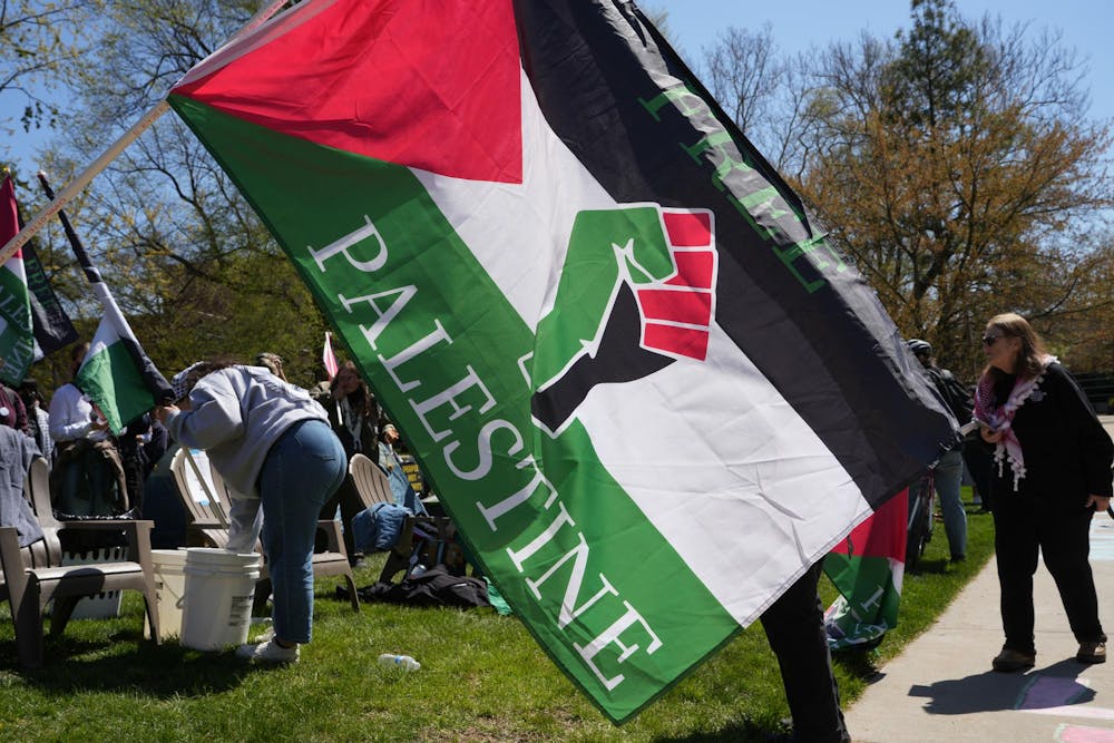A protester waves a “Free Palestine” flag during a Gaza solidarity encampment in People’s Park on April 25, 2024.