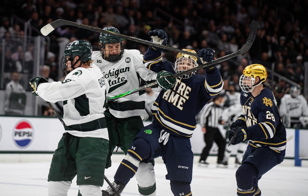 Michigan State senior Matt Basgall (9), Michigan State sophomore Colin Ralph (4), Notre Dame junior Evan Werner (19) and Notre Dame graduate student Sutter Muzzatti (28) compete during a game at Munn Ice Arena in East Lansing, Michigan, on Friday, Feb. 20, 2026.