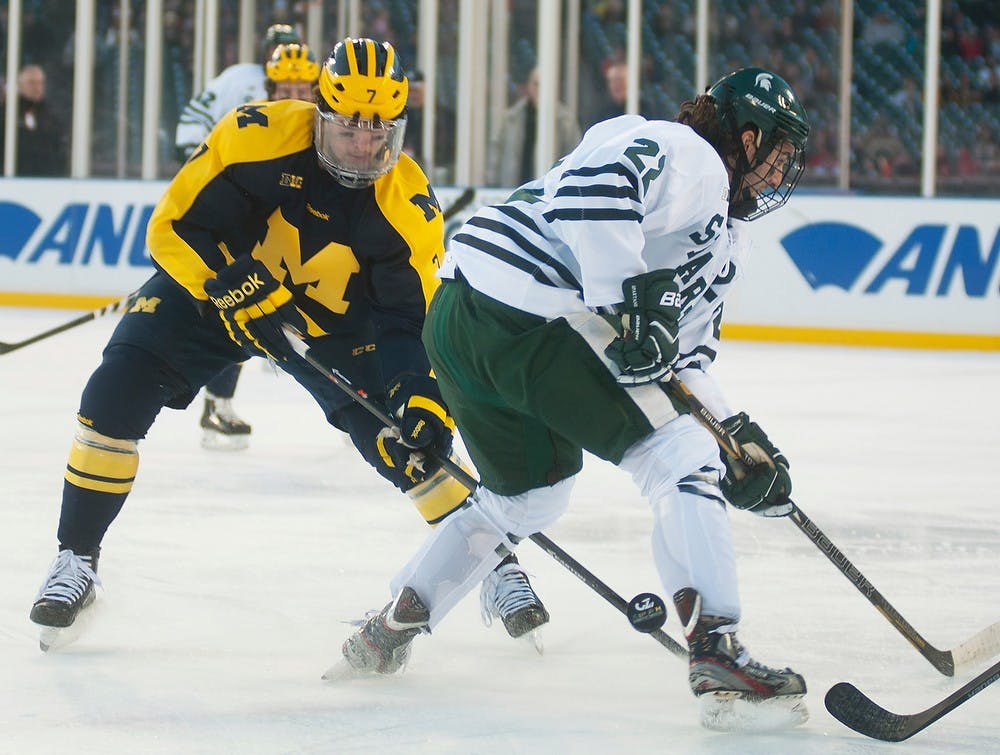 	<p>Senior forward Lee Reimer tries to steal the puck from Michigan forward Phil Di Giuseppe during the Great Lakes Invitational consolation game Dec. 28, 2013, at Comerica Park in Detroit. The Spartans defeated the Wolverines, 3-0. Danyelle Morrow/The State News</p>